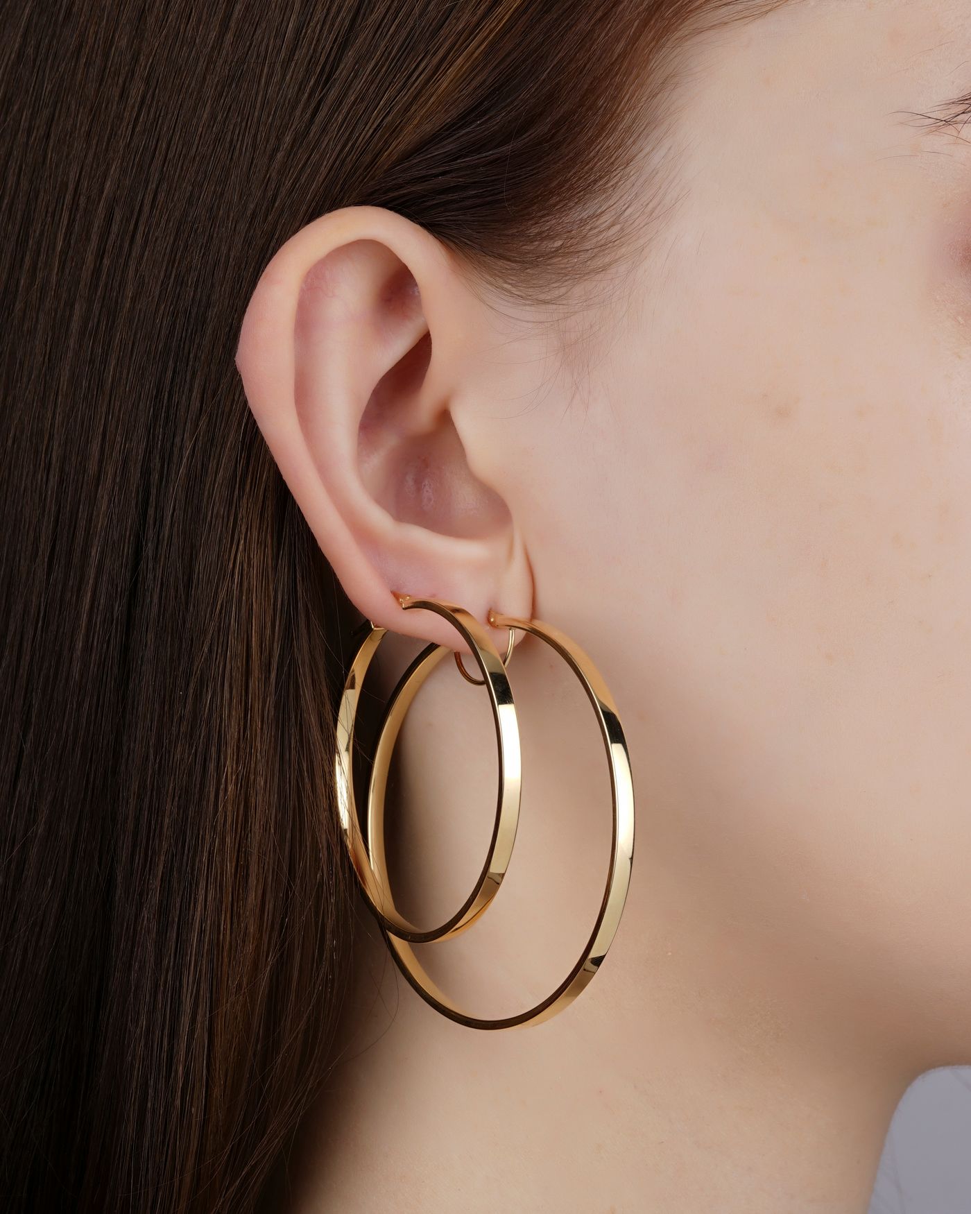 Gold hoop earrings worn by a model